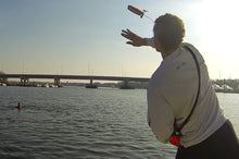 Load image into Gallery viewer, Man throwing the Switlik TechFloat - Inflatable Rescue Device to the man on the water