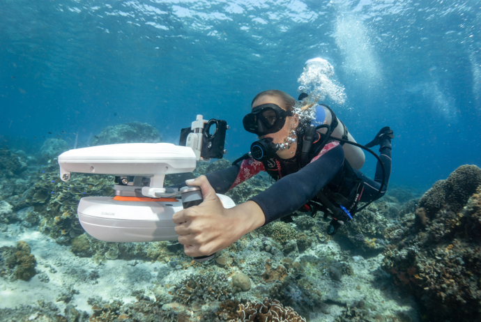Diver underwater with the Sublue WhiteShark Tini Underwater Scooter