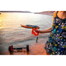 Load image into Gallery viewer, Woman holding Yujet wireless remote with the background of Yujet Surfer Electric Jetboard EJB-01 floating