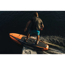 Load image into Gallery viewer, Back view of a man in a black shirt riding Yujet Electric Surfobard EJB-01