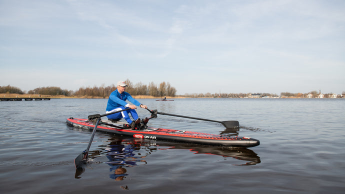 Man rowing on the ROWONAIR Mojo 18' Inflatable Paddle Board with RowOnAir Universal Rowing Unit