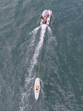Load image into Gallery viewer, People on board the Takacat T460LX Inflatable Boat with a paddleboard behind