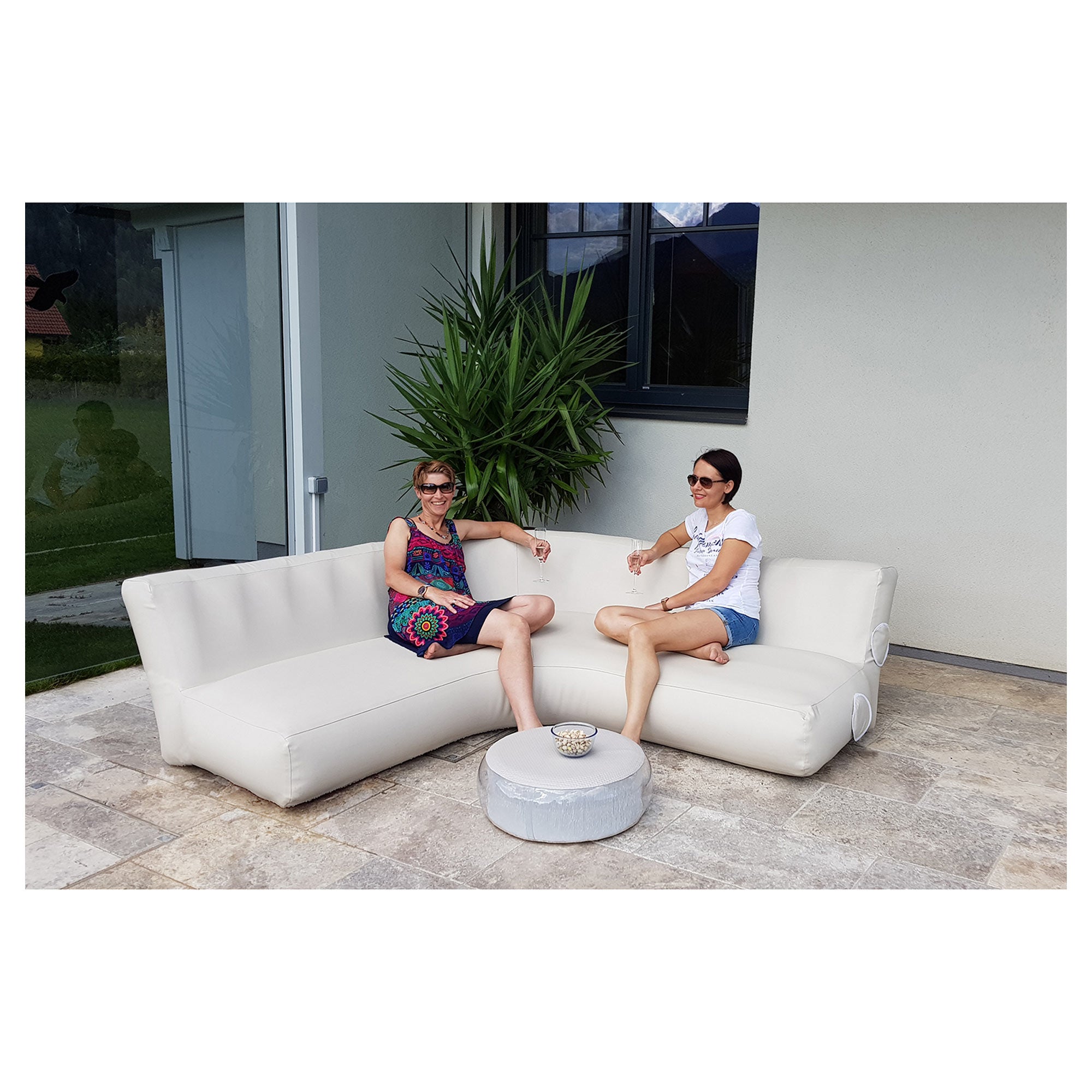 Women sitting on the YachtBeach Air Sofa 5'x5'x2' in the balcony area