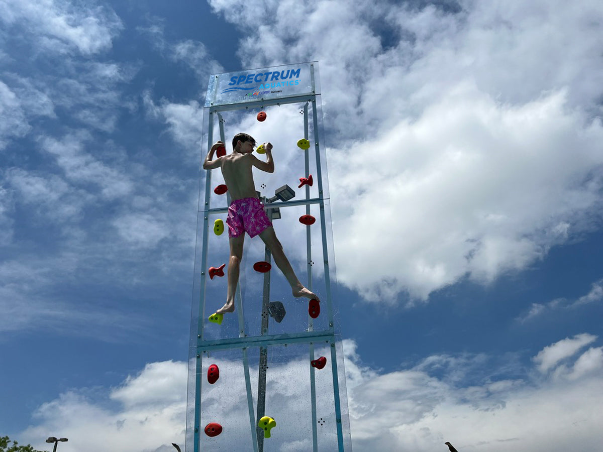 young adult climbing the Spectrum Aquatics Kersplash Challenger Pool Climbing Wall crystal