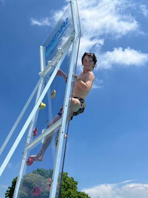 Young adult climbing the Spectrum Aquatics Kersplash Challenger Pool Climbing Wall