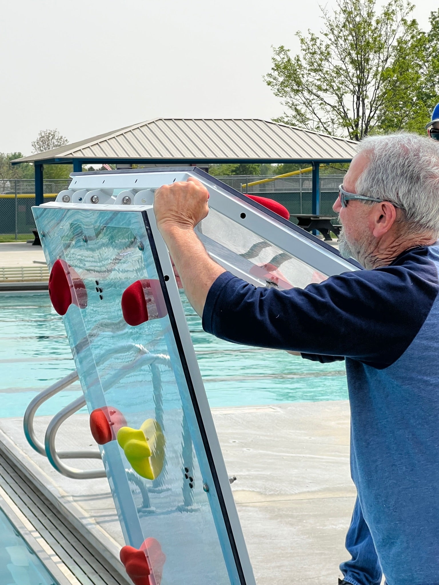 Man installing the Spectrum Aquatics Kersplash Challenger Pool Climbing Wall