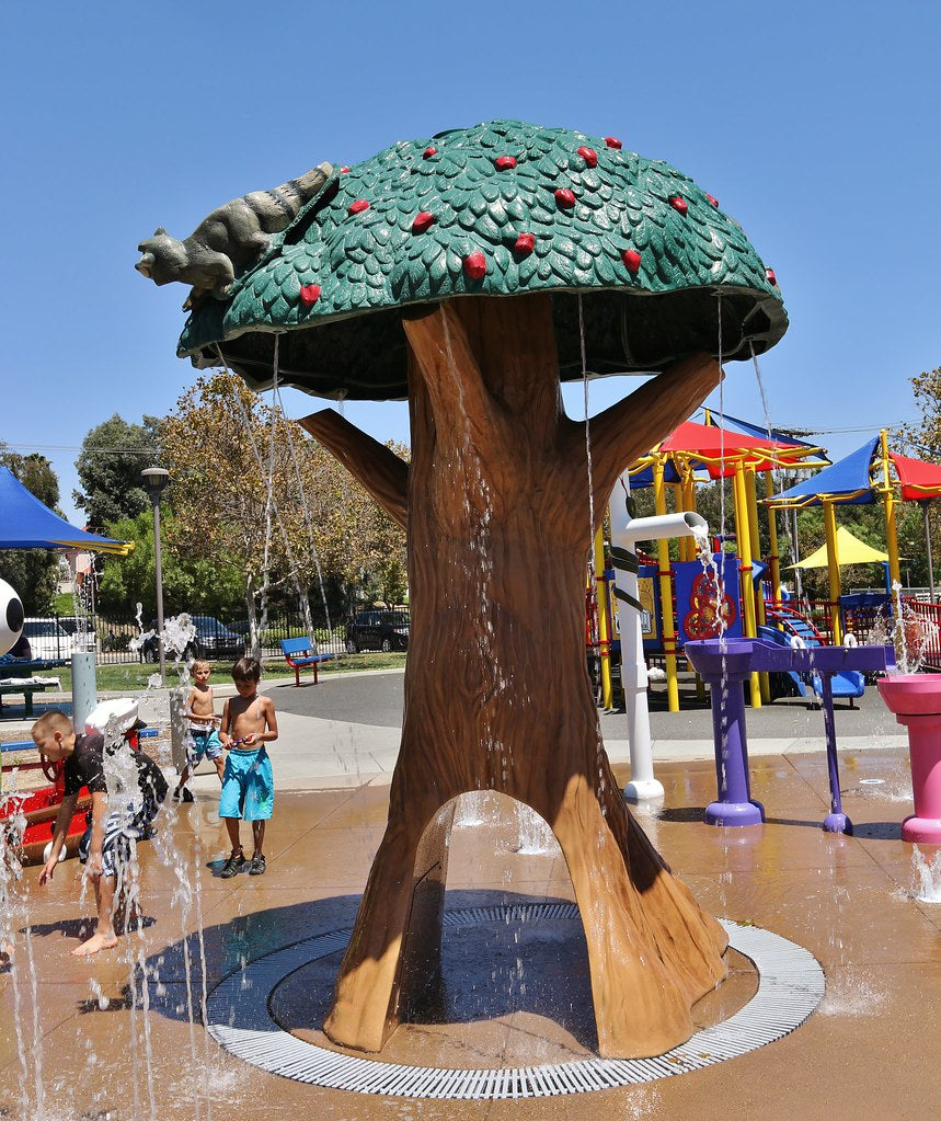 Children Playing On A Splashpad wWith aA Rain Drop Products Rain Tee With Tunnel Water Feature