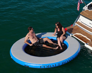 Paradise Pad 8' Round Splash Island Lake Pad with couple on board behind the yacht