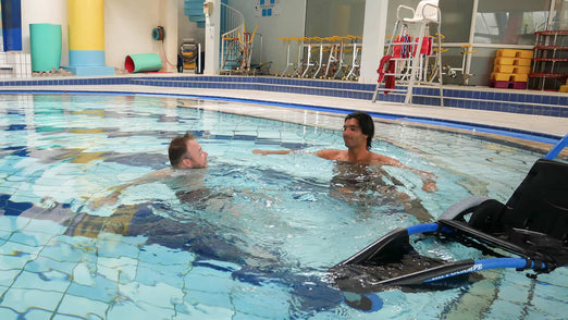 Men floating in pool next to Vipamat Hippocampe Pool Wheelchair