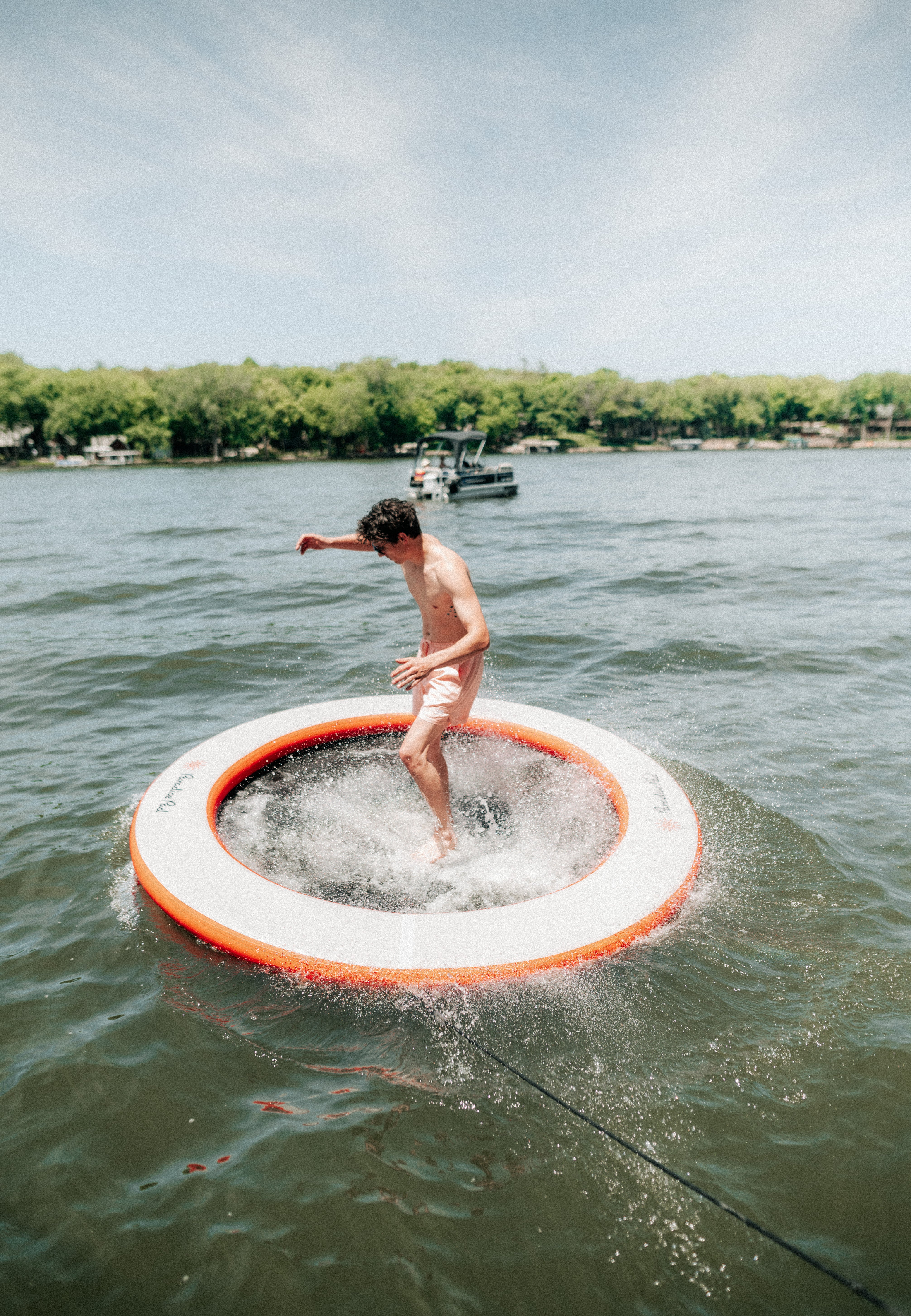Paradise Pad 8' Round Splash Island Lake Pad with an adult jumping into it.