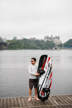 Load image into Gallery viewer, Man standing beside the SAVA All-New E1-B Electric Surfboard black red