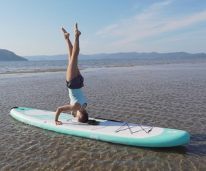 Woman doing headstand on Sipaboards motorized paddle board