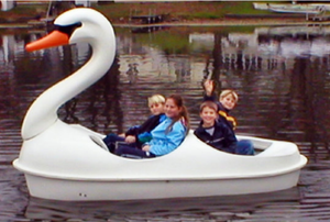 four people having fun in the Adventure Glass Swan Classic 4 Person Paddle Boat