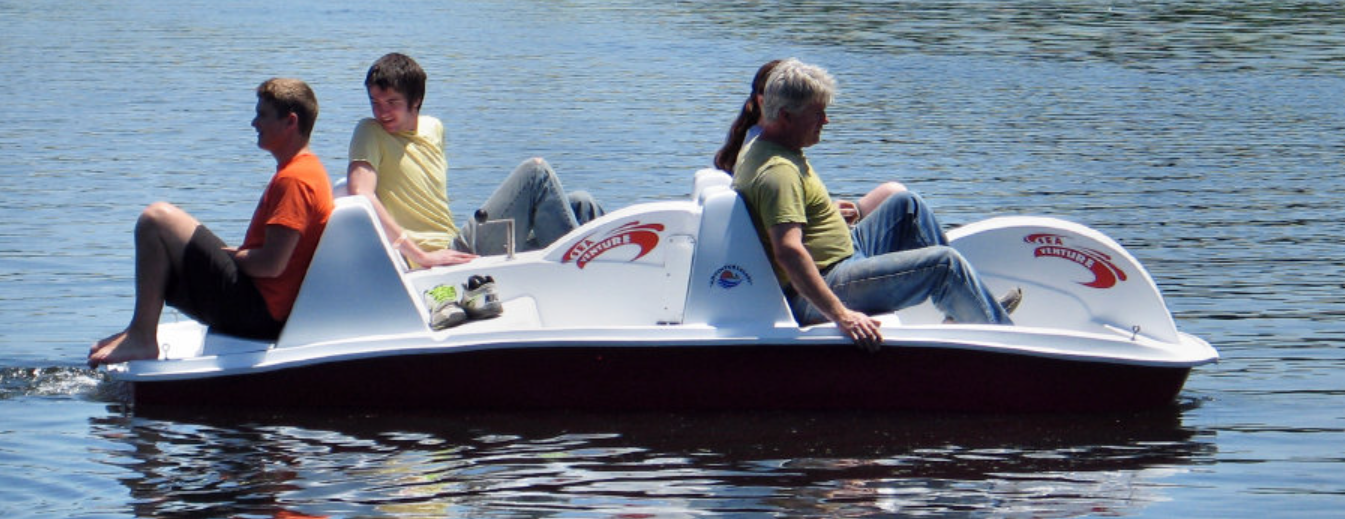 Adventure Glass 6 Person 4 peddler SeaVenture Paddle Boat with a family of four on board