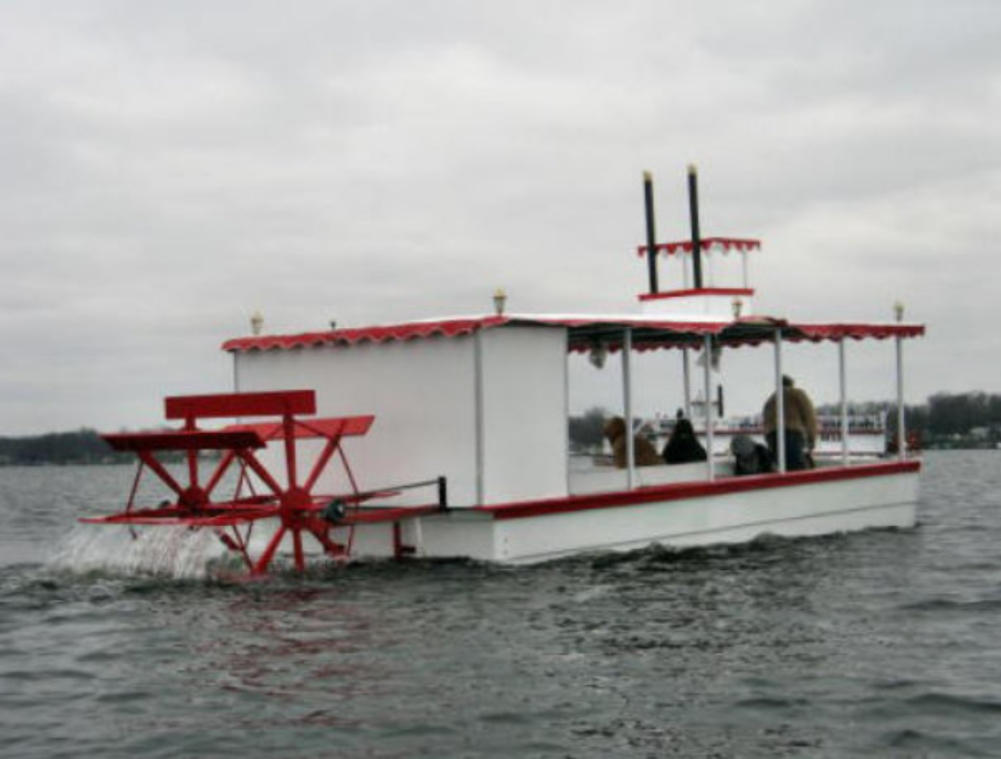 Adventure Glass 20 Person Genuine Sternwheel Riverboat traveling across the river