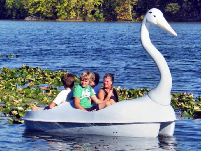 Four people riding Adventure Glass Swan Classic 4 Person Paddle Boat