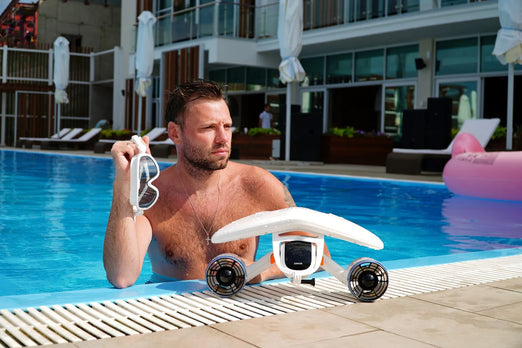 Man on the pool with the Sublue WhiteShark Mix Underwater Scooter