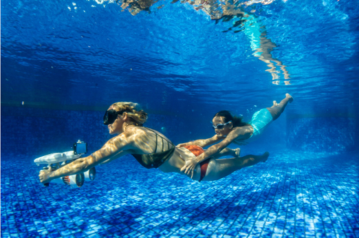 Mother and daughter underwater with the Sublue WhiteShark Tini Underwater Scooter 