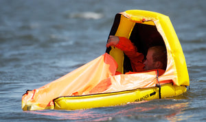 Switlik Inflatable Single Place Life Raft on a half closed with man inside