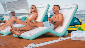Man and woman having fun sitting on the Yachtbeach Sun Lounger Superior Single 29"x 62" on top of the platform.