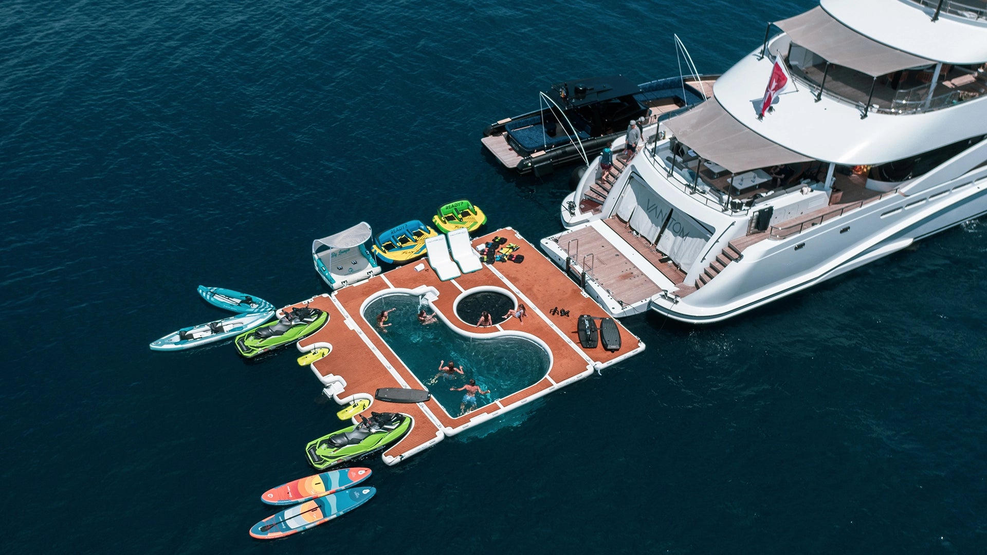 Yachtbeach Toy Dock 8.20 Dropstitch 27'x6.7' with other platforms behind the yacht.