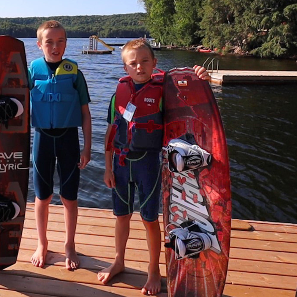 Rave Impact™ Red Brick wakeboard with Youth bindings with two boys holding on it.