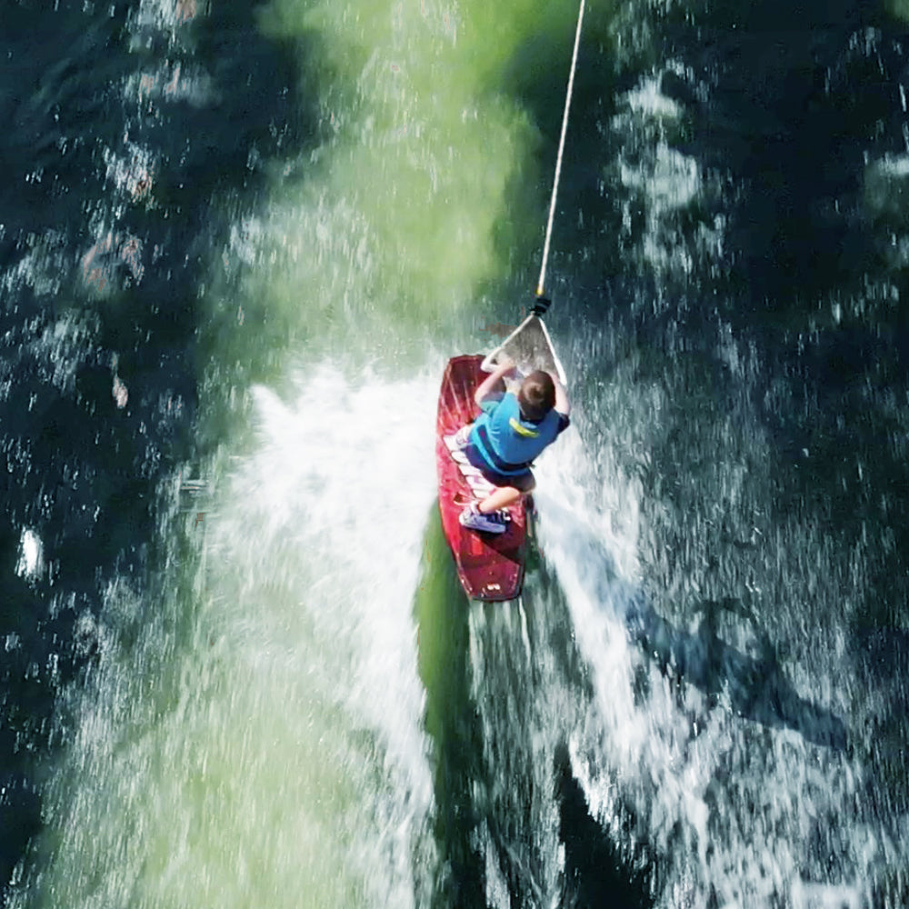 Rave Impact™ Red Brick wakeboard with Youth bindings with the boy top view.