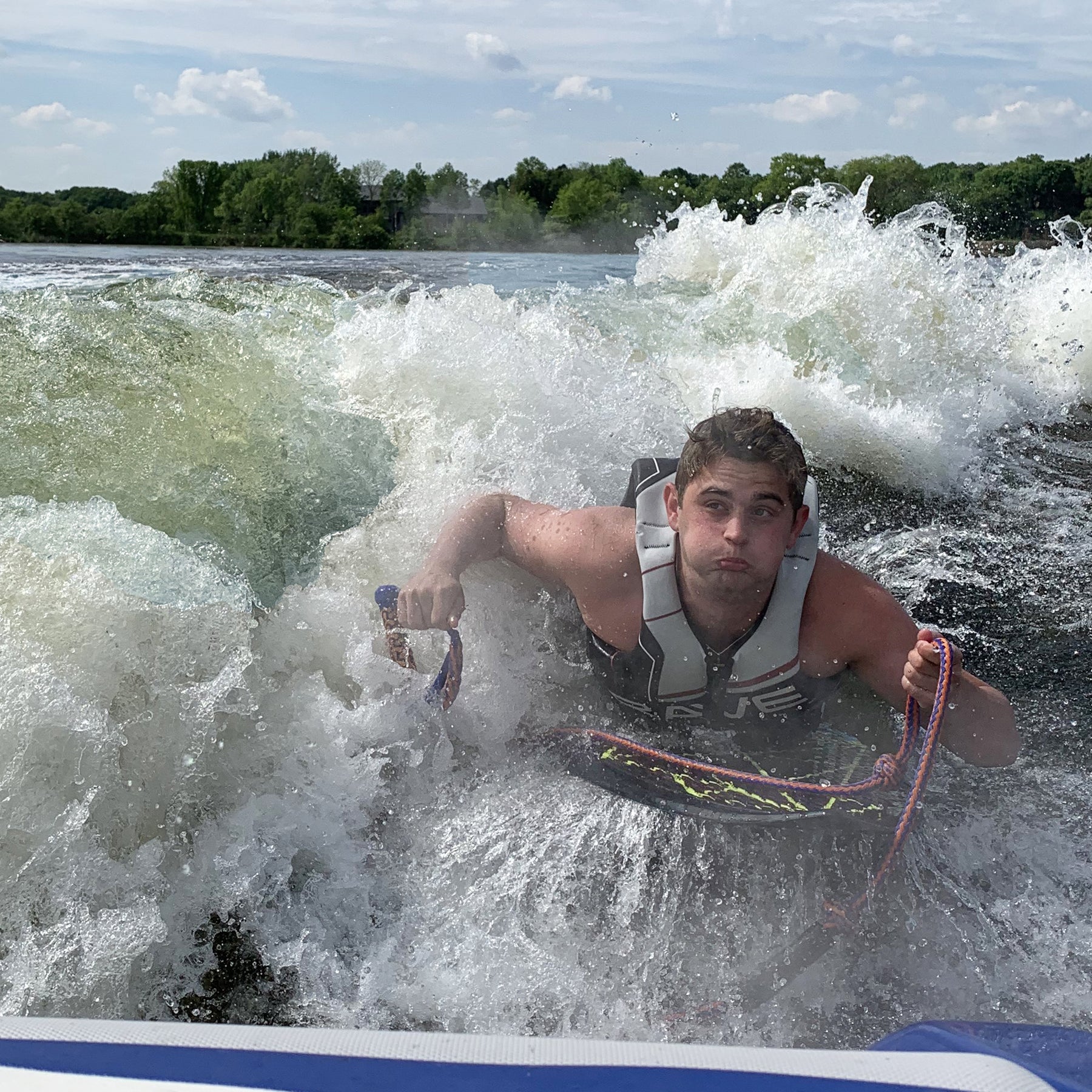 Rave Sports Fractal Wake Surf Board with a man riding on it.