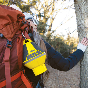 Yellow WOW SOUND Buoy front attached on female hikers bag