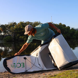 Inflatable stand up paddleboard - Man setting the Eco Outfitters Inflatable Stand Up Paddle Board 10'6