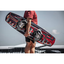 Load image into Gallery viewer, Man holding the Rave Lyric Red Wakeboard with RAVE boots