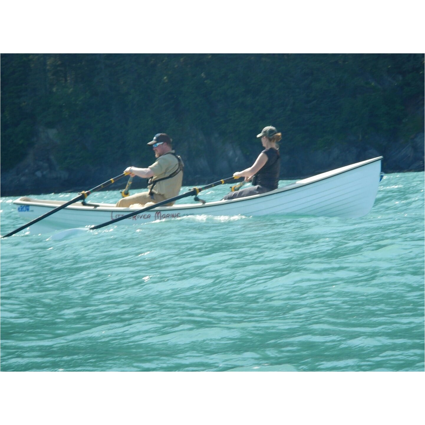 Man and woman rowing with the Little River Marine Legacy 5M Adventure Craft