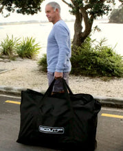 Load image into Gallery viewer, Man carrying the Scout Inflatables 430 Scout 14’ x 3.5” inside the bag