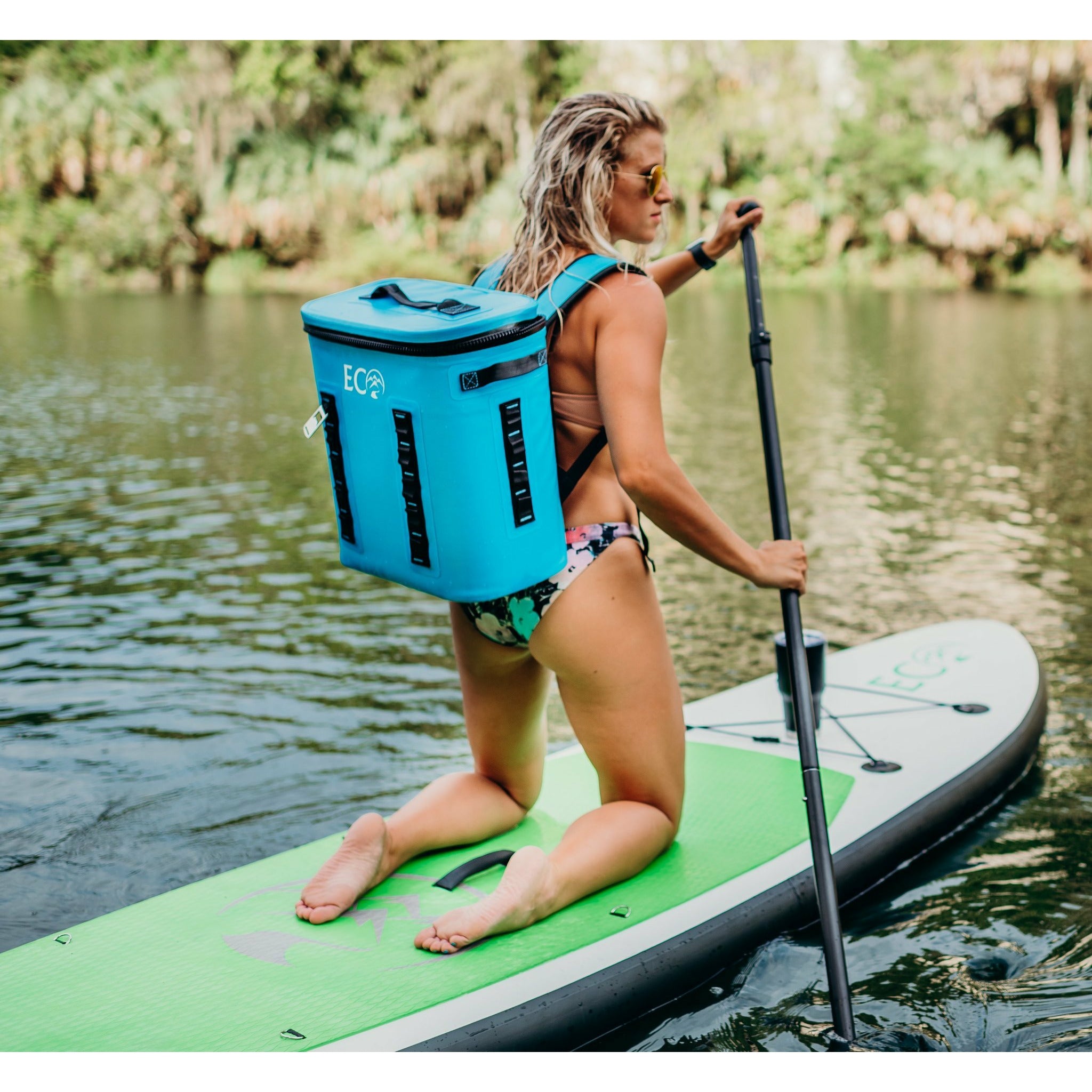 Inflatable stand up paddleboard - woman with an eco cooler boarding the Eco Outfitters Inflatable Stand Up Paddle Board 10'6 green 