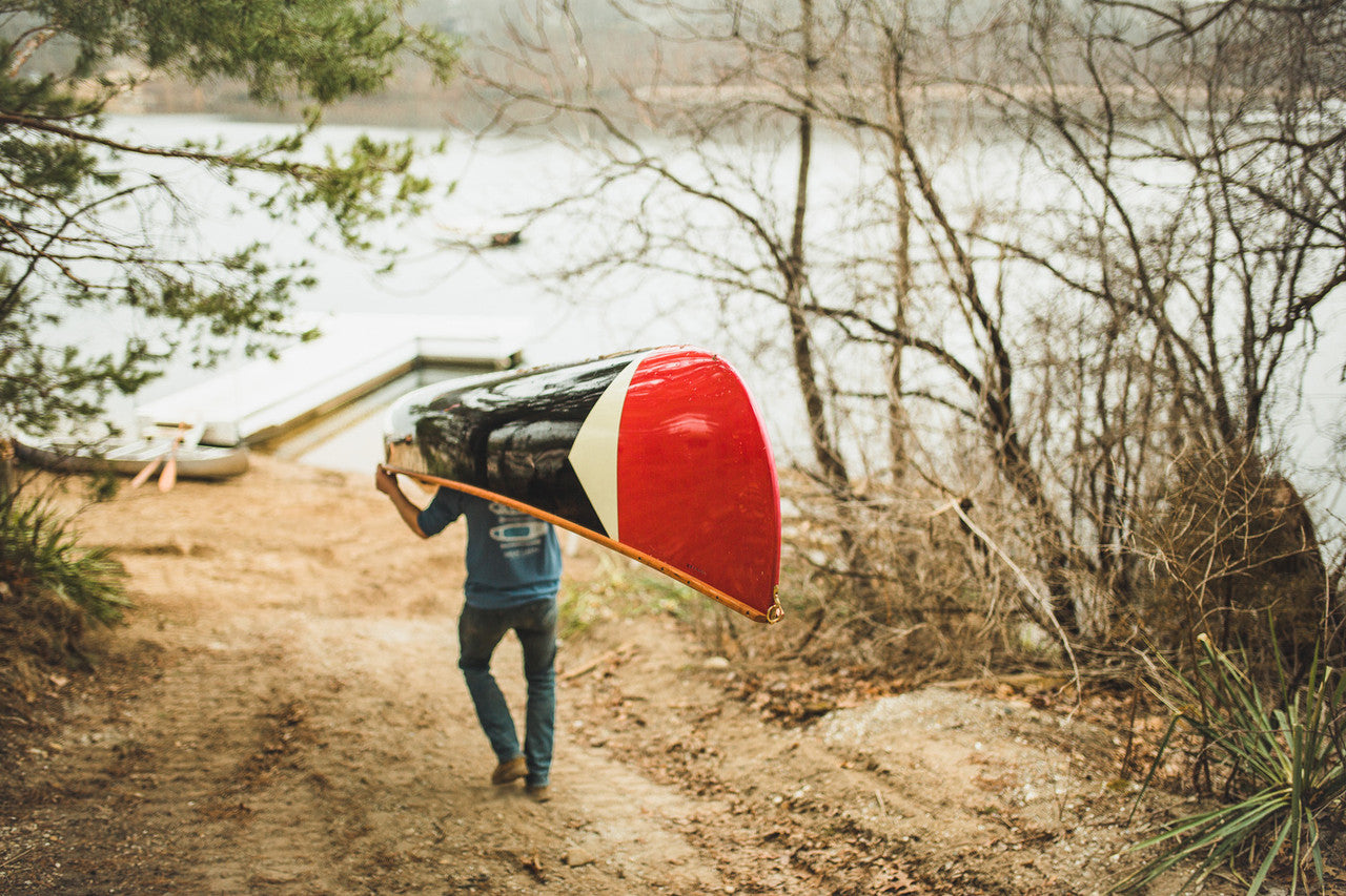 Man carrying the Merrimack Canoes Sanborn + Merrimack Pickwick Canoe