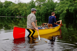 Men with some stuffs loaded in the Merrimack Canoes Prospector - 16' Canoe