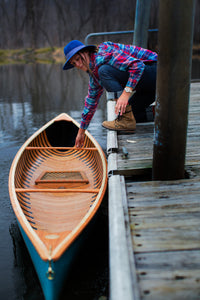 Woman with the Merrimack Canoes Solitaire 11'9" Solo Canoe at the docking area.