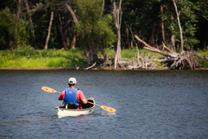Man canoeing with the Merrimack Canoes Solitaire 11'9" Solo Canoe