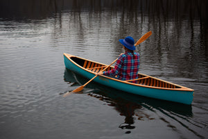 Woman boating at the lake with the Merrimack Canoes Solitaire 11'9" Solo Canoe