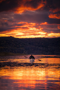 Man canoeing with the Merrimack Canoes Solitaire 11'9" Solo Canoe in the afternoon at the lake