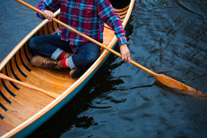 Woman paddling with the Merrimack Canoes Solitaire 11'9" Solo Canoe