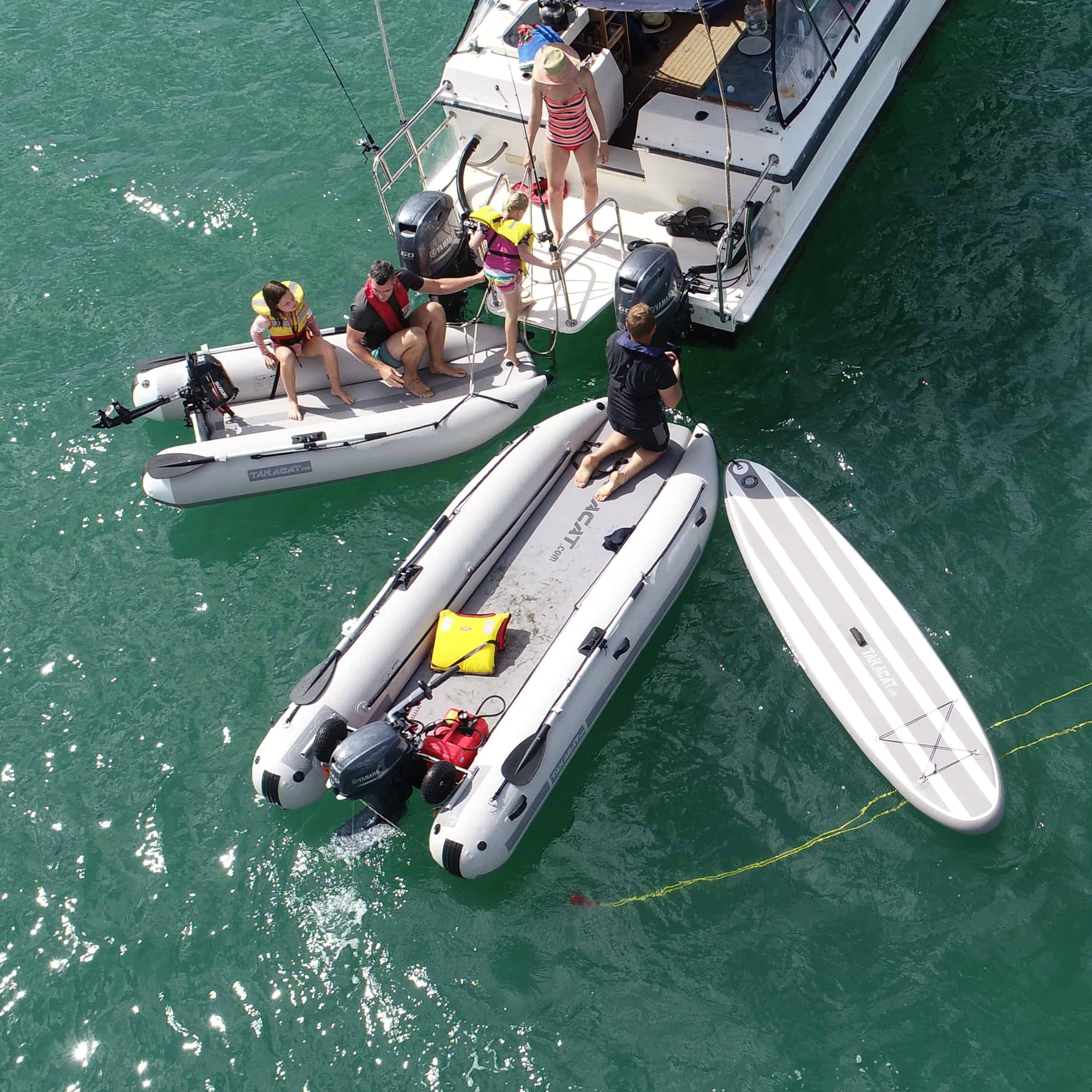 family boarding the vessel with Takacat Inflatable Boats and paddle board at the back