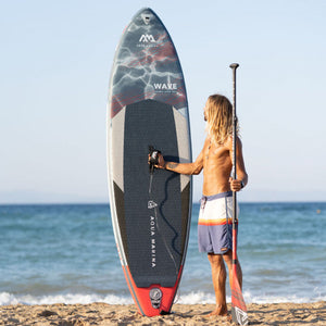Inflatable Stand Up Paddleboard - Man standing beside the Aqua Marina Wave 8'8" Inflatable Stand Up Paddle Board