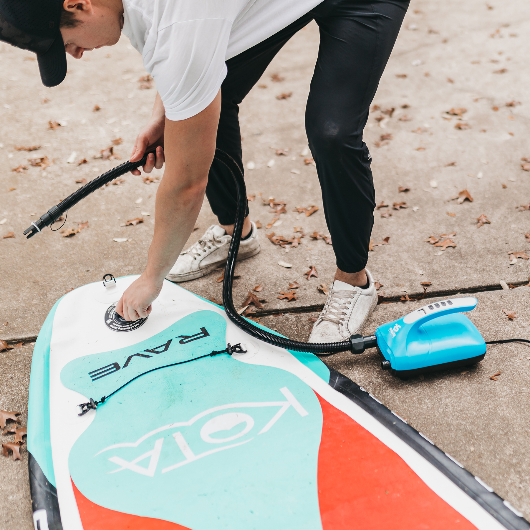 A man preparing iSUP to be inflated ussing Rave Rapid Dual Stage 12VDC inflator