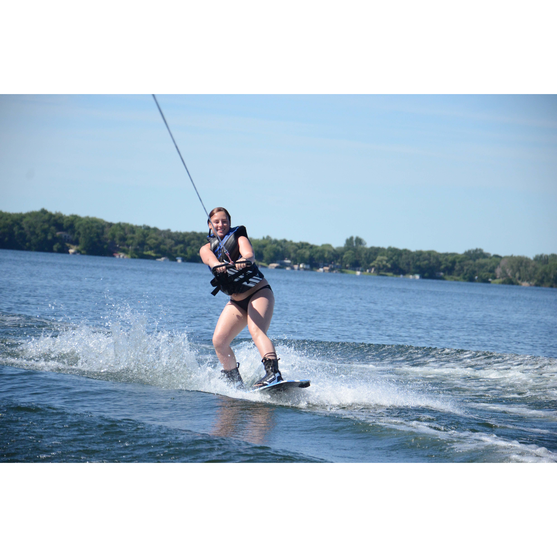 A woman using the Rave Freestyle Blue Wakeboard with RAVE boots