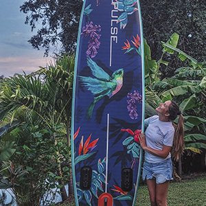 A Girl Showing th front part of Pulse The Honey 10'6" Inflatable Stand Up Paddleboard