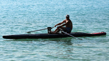 Load image into Gallery viewer, Man rowing on the ROWONAIR iCoaster 18&#39; Inflatable Rowing Board