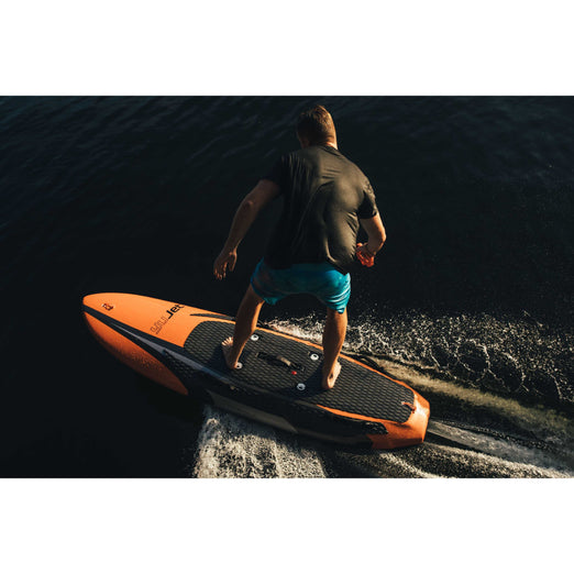 Back view of a man in a black shirt riding Yujet Electric Surfobard EJB-01 
