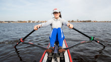 Load image into Gallery viewer, Woman rowing RowOnAir board with the ROWONAIR RowMotion Universal Rowing Unit