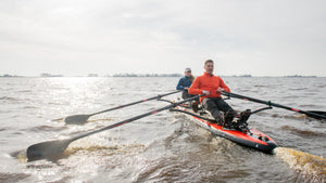 Man and woman tandem rowing on the ROWONAIR Mojo 18' Inflatable Paddle Board with RowOnAir Universal Rowing Unit